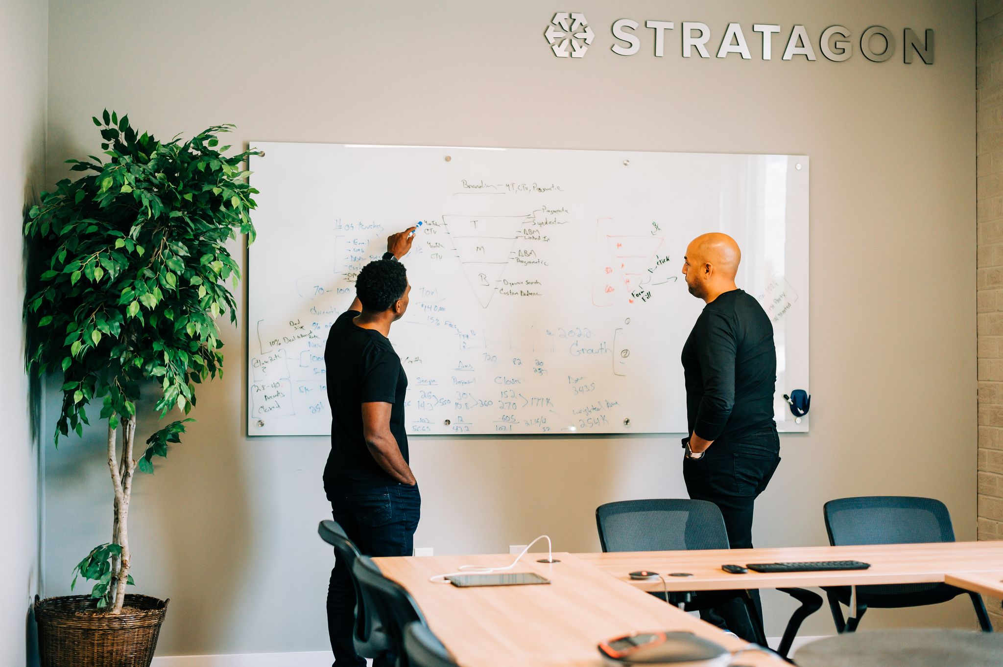 Alex Moore, senior partner at Stratagon writes on a white board and shares with Ryan Burkett.