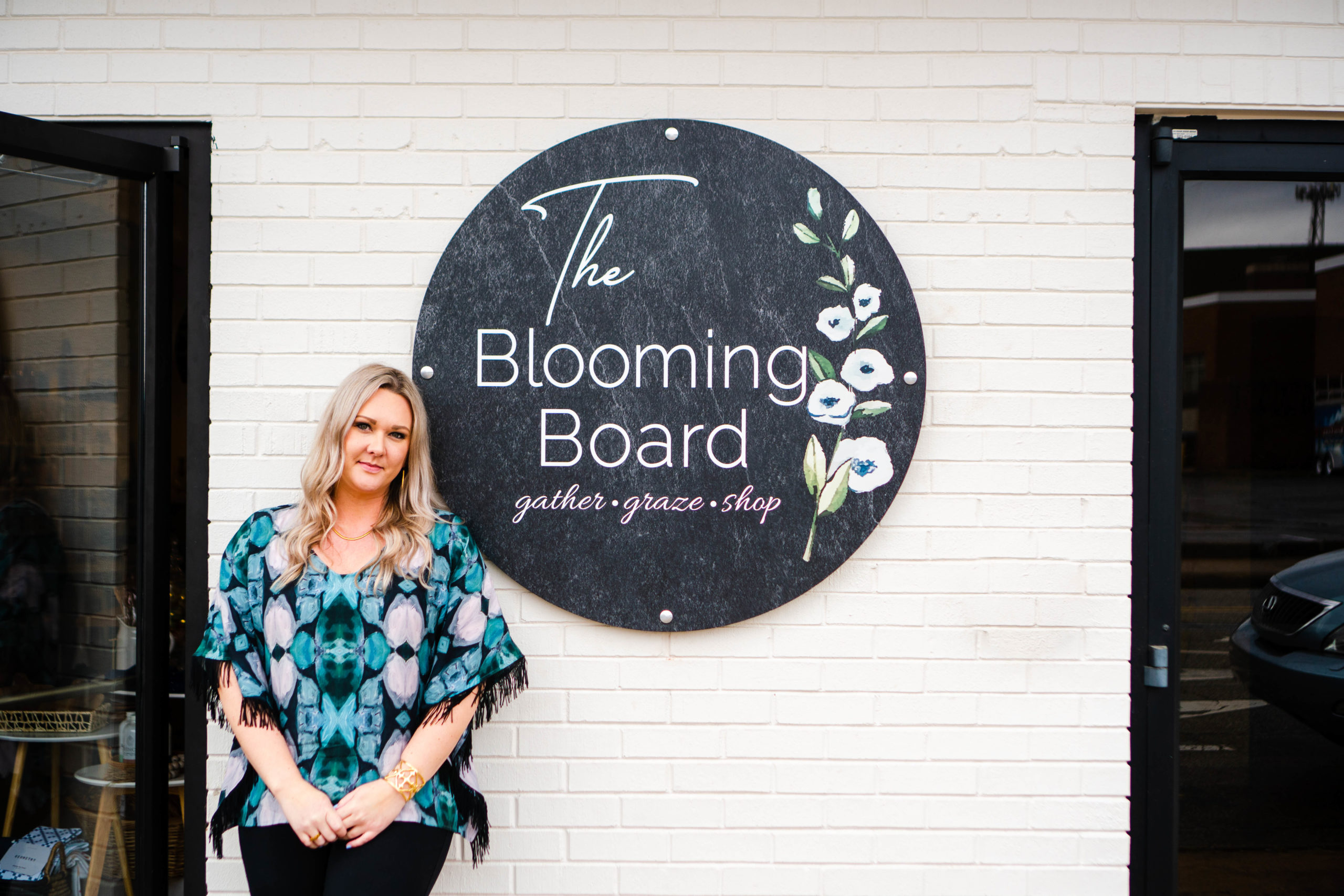 Brandi Crumley, owner of the Blooming Board, a charcuterie board shop in High Point, NC stands in front of her storefront in downtown High Point.
