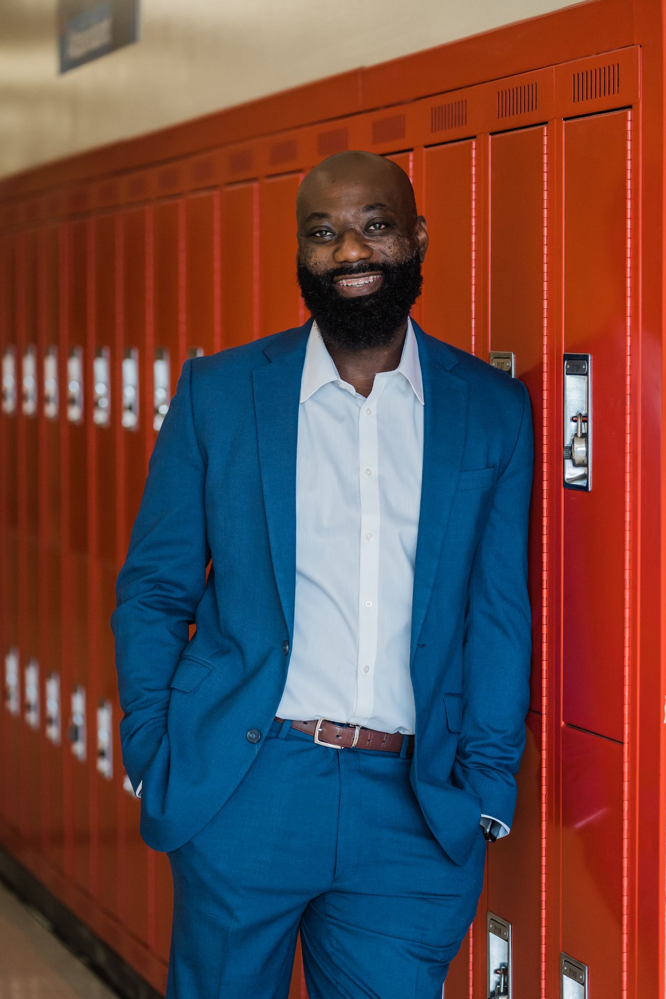 Dr. Marcus Gause leans against red lockers in the hallways of T. W. Andrews High School in High Point.