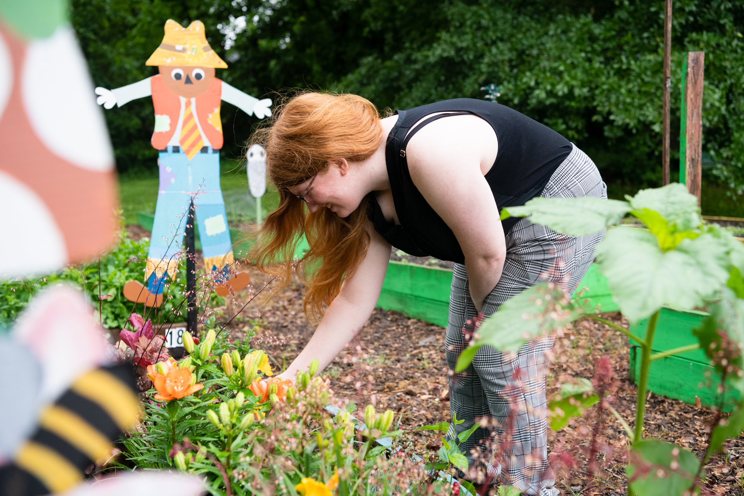 HPU Vista, Chloe Lewis checks on plants in the Burns Hill Community Garden.