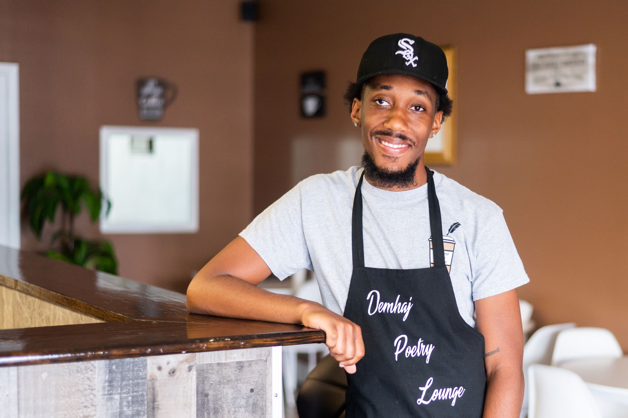 Jahmed Williams, son of Demhaj Poetry Lounge owner, Bridgette stands at the coffee shop counter.
