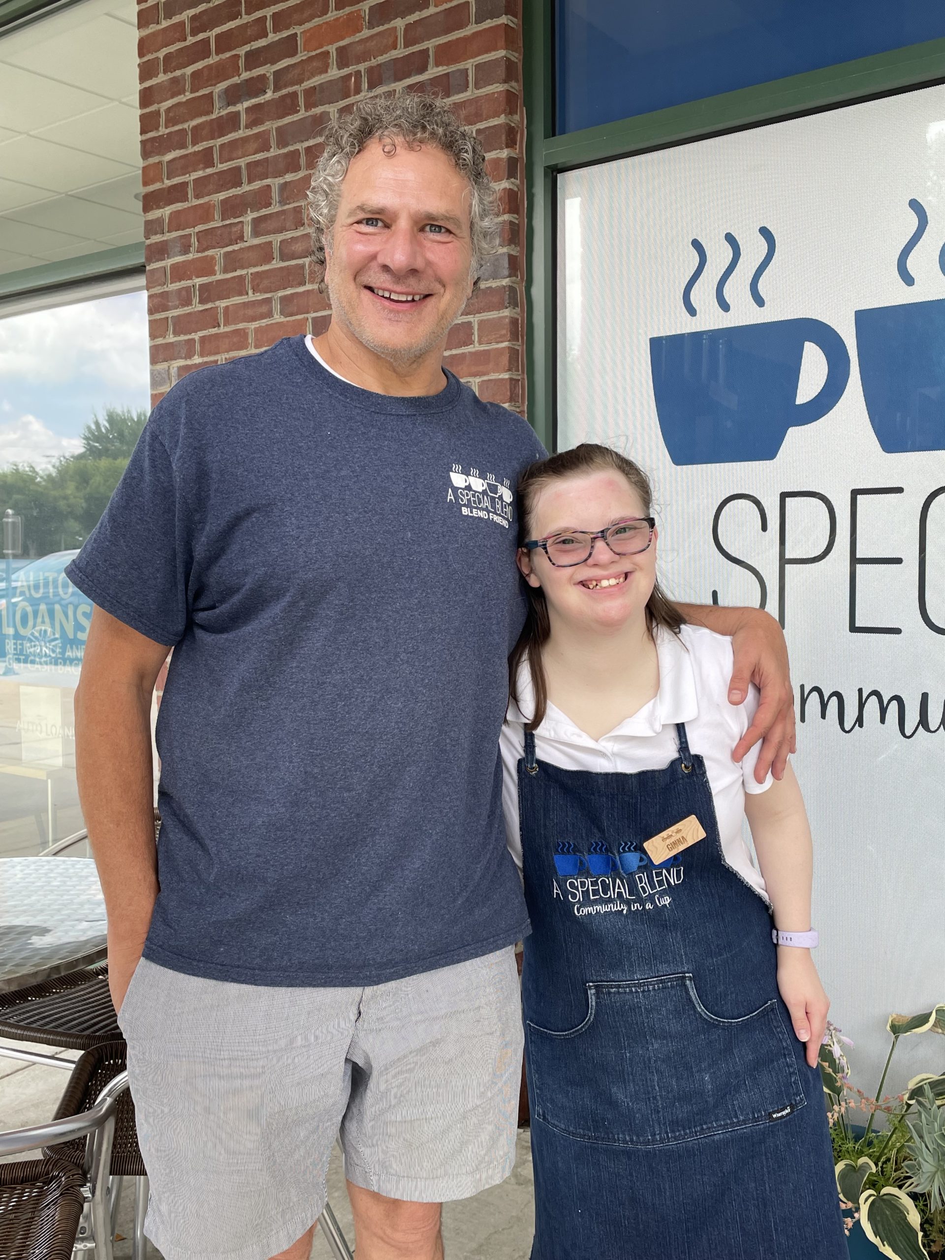 A leader at A Special Blend stands with an employee in front of the coffee shop in Greensboro, NC.