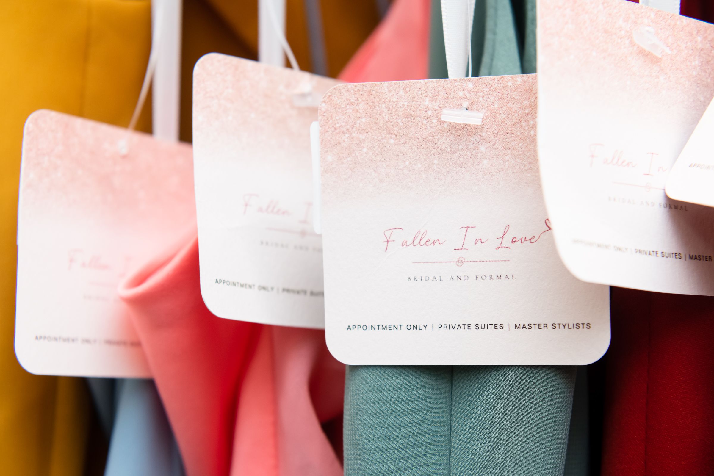 Tags hang on bridesmaid dresses that say Fallen In Love.