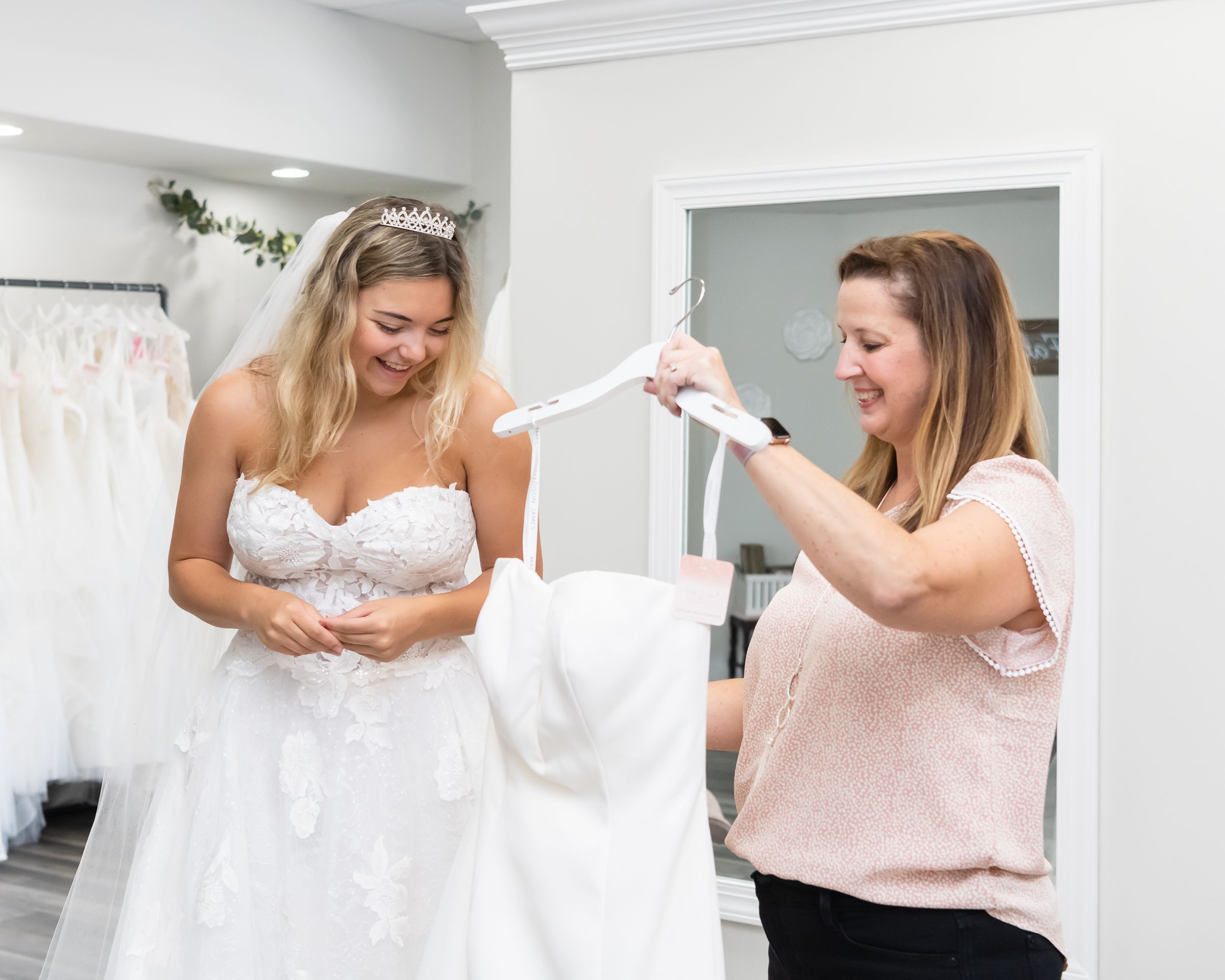 Sara Cook, co-owner of Fallen In Love Bridal helps a bride find a dress.