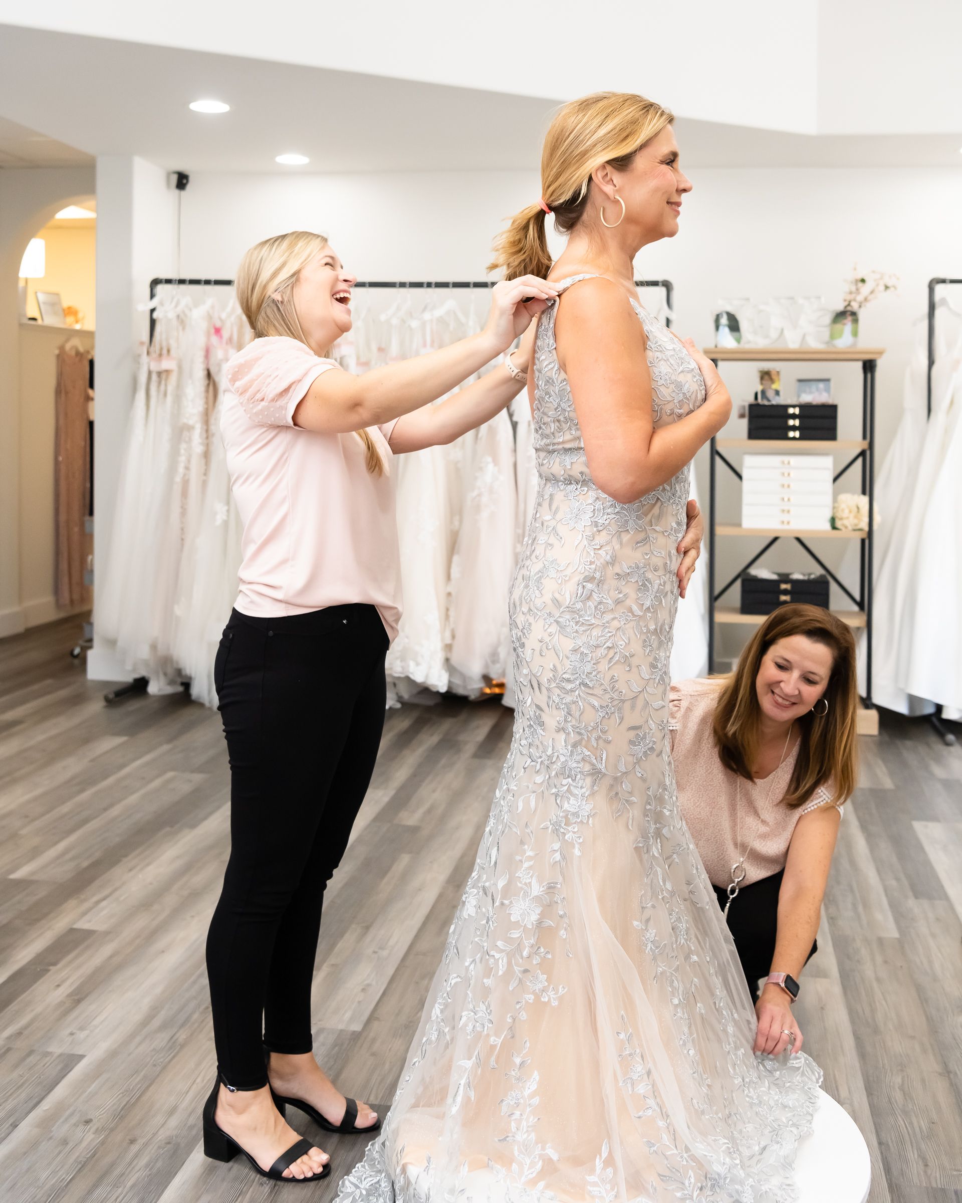 Mary Beth helps a mother of the bride try on a dress.