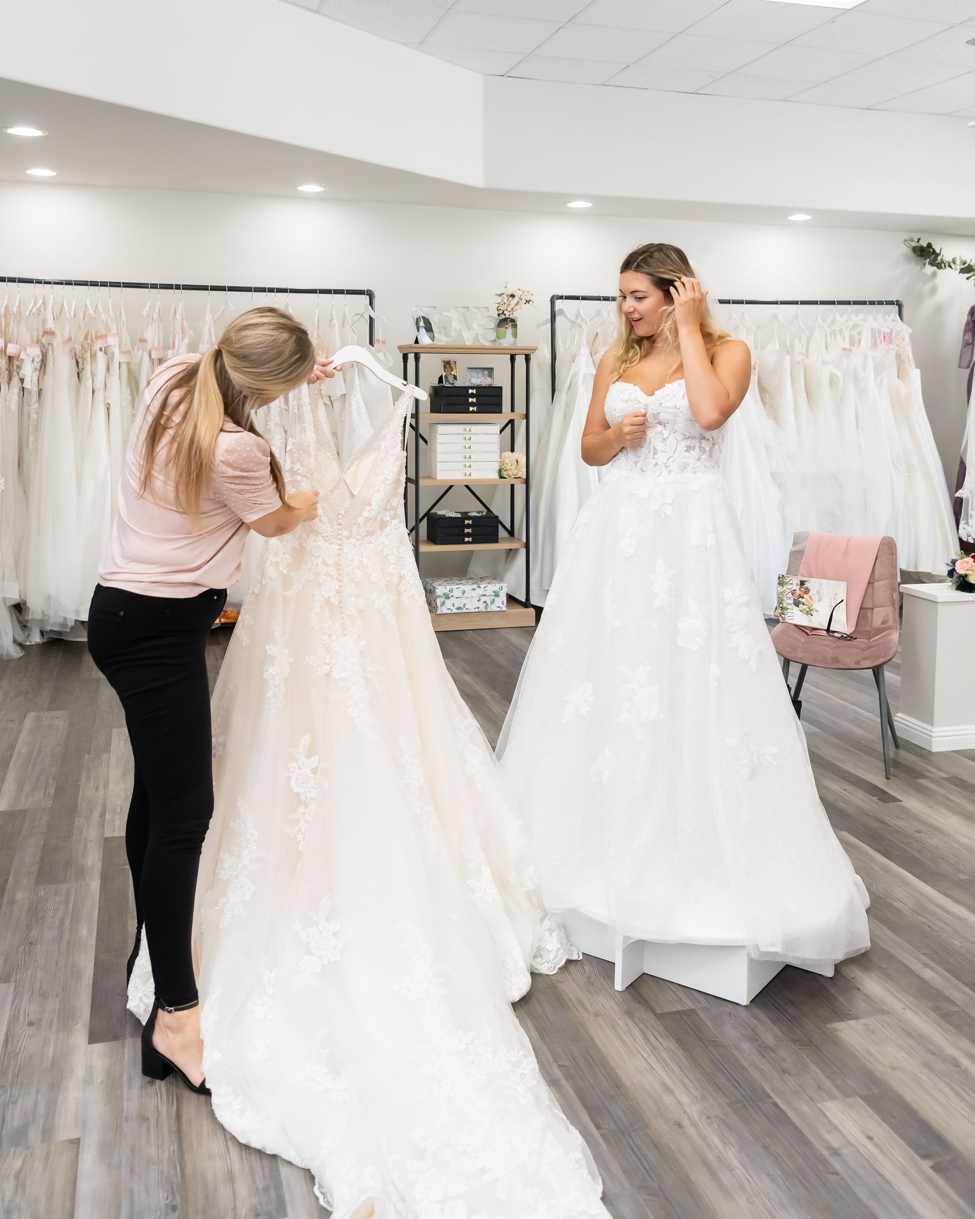 Mary Beth Moore shows a bride a dress from the High Point bridal boutique, Fallen In Love.