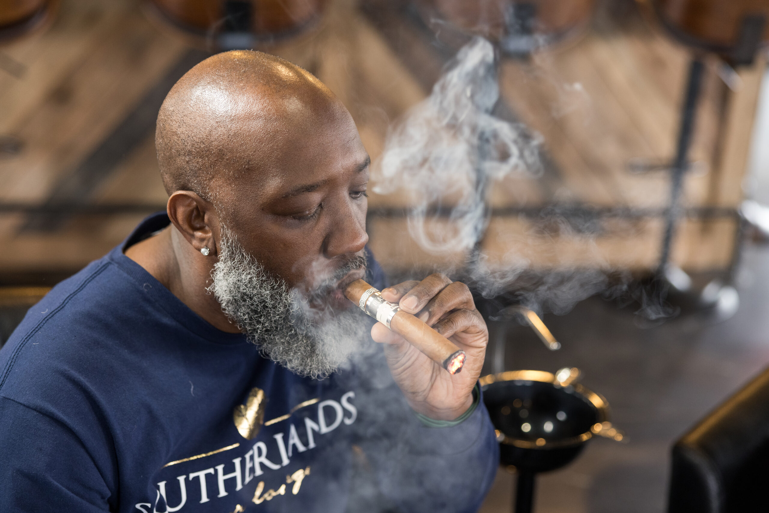 Wayne Southerland, owner of Southerlands Cigar Lounge in High Point, NC smokes a cigar.