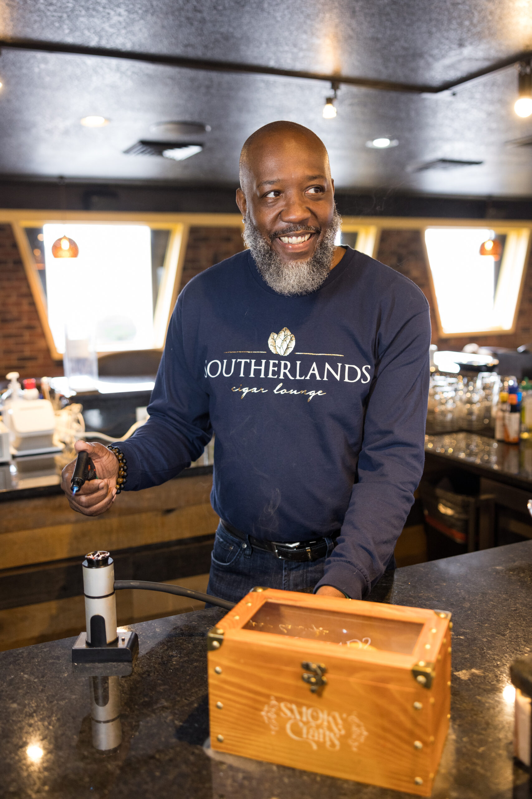 Wayne Southerland infuses a drink with smoke at Southerlands Cigar Lounge in High Point, NC.