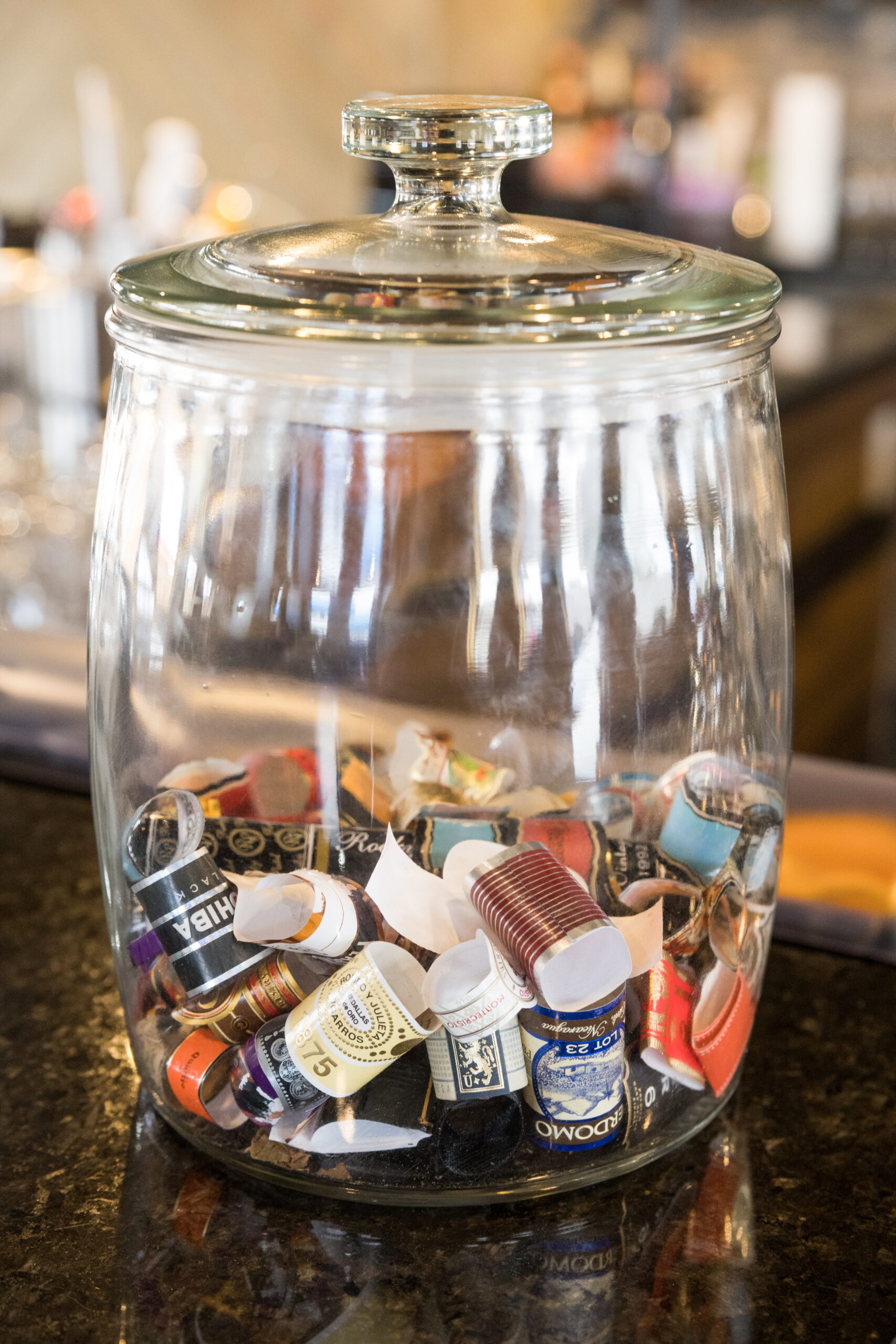 A jar of cigar labels sits on a counter.