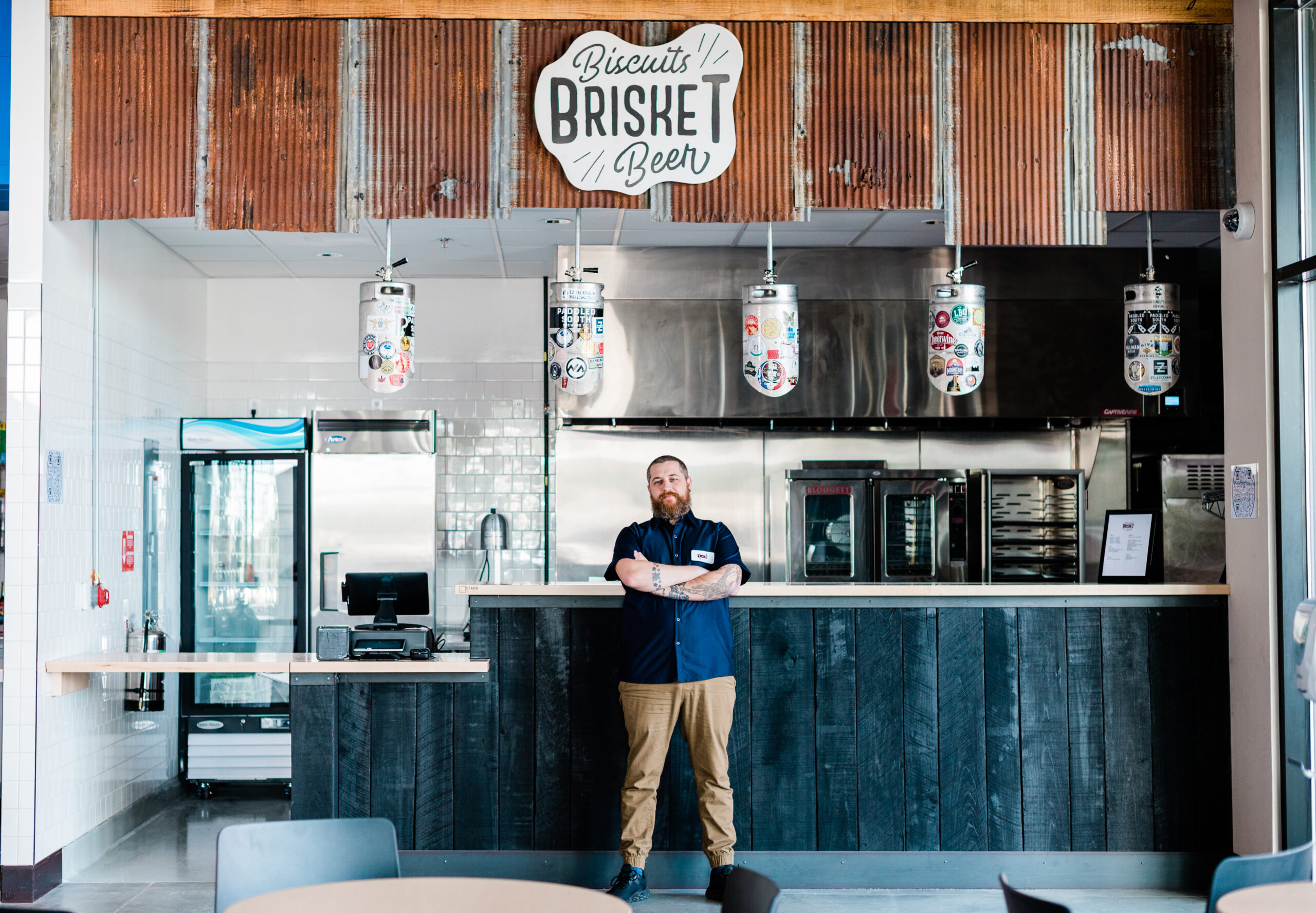Chris Ryker, owner of Biscuits Brisket & Beer stands in front of his restaurant in High Point, NC at the food hall, Stock+Grain Assembly.