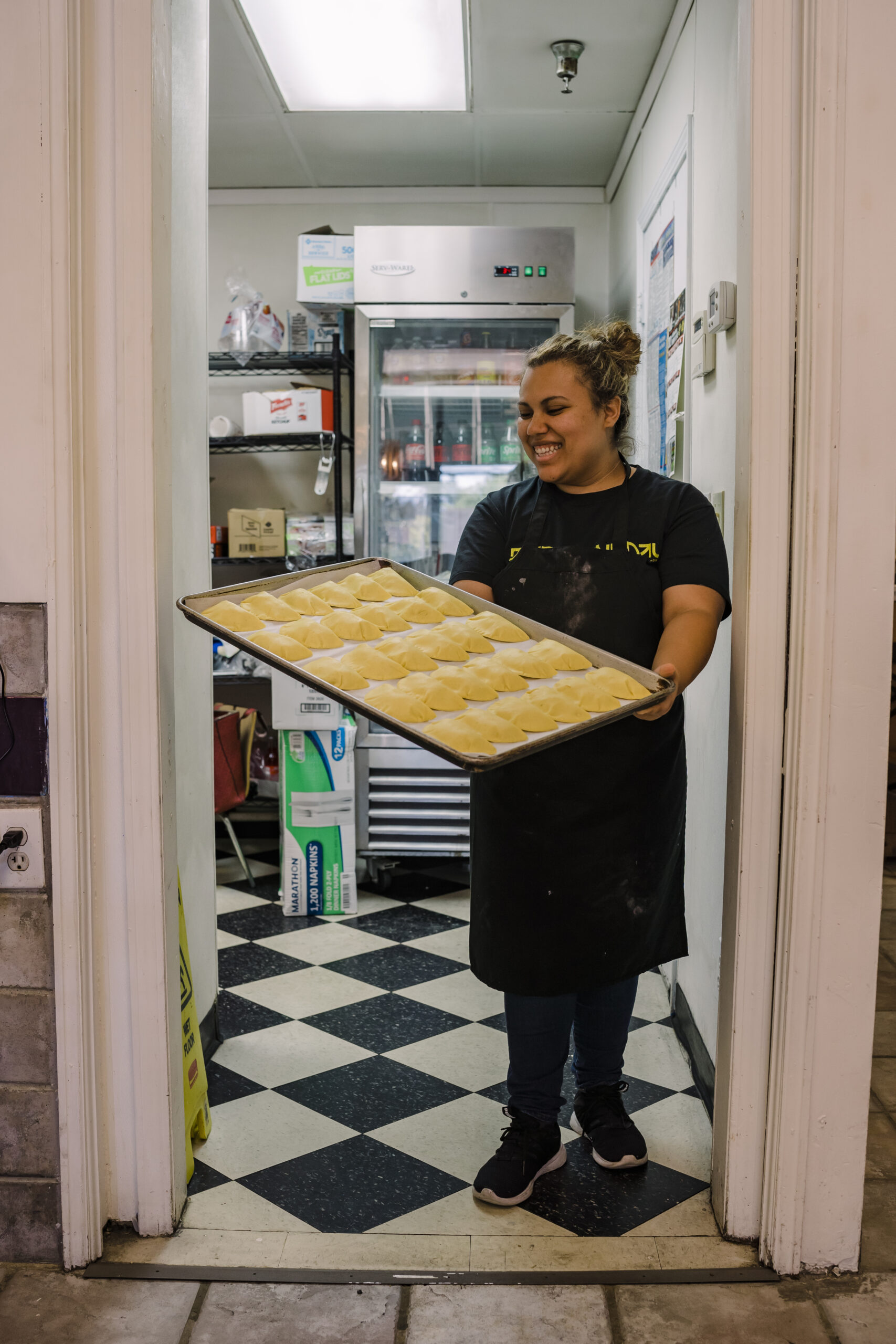 Maria holds a tray of freshly baked empanadas at Sofrito.