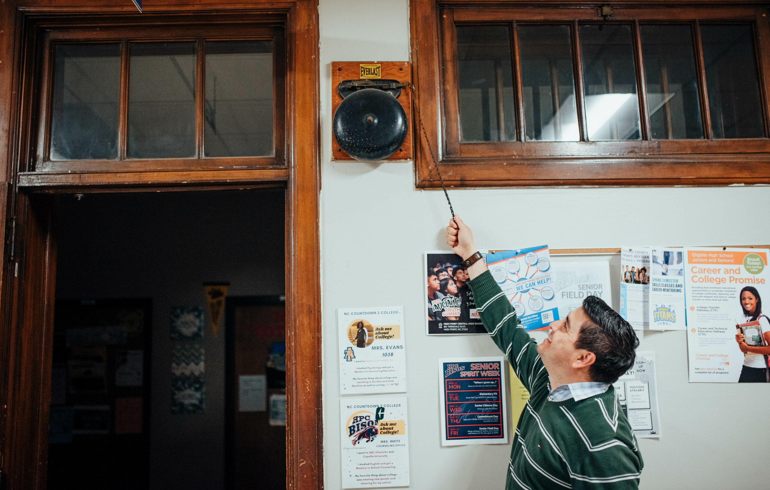 Assistant Principal Héctor Ancizar Gómez-Argote rings an antique bell at HP Central in High Point, NC.
