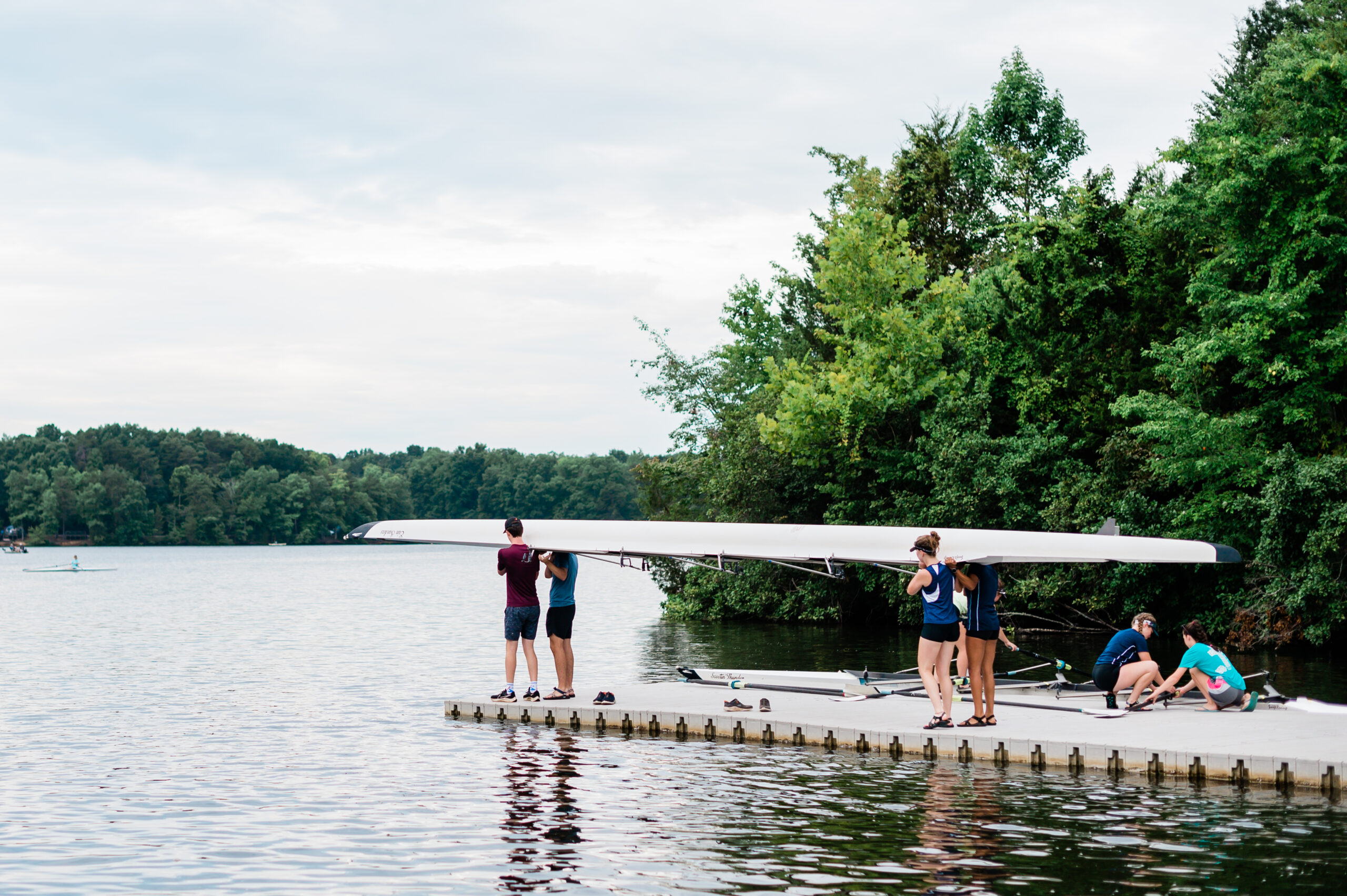 Rowers carry a boat down the dock at Oak Hollow Lake in High Point, NC.