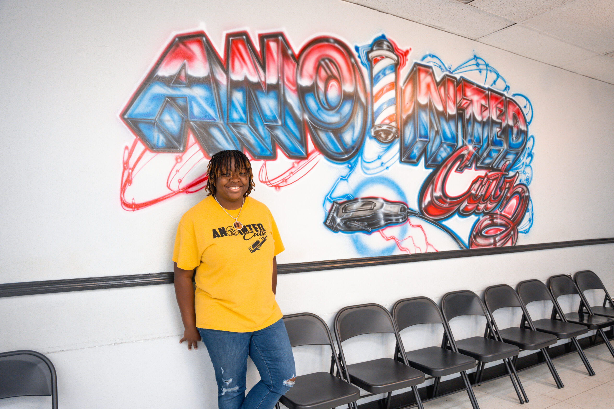 Shauna Greene poses in front of Anointed Cutz sign