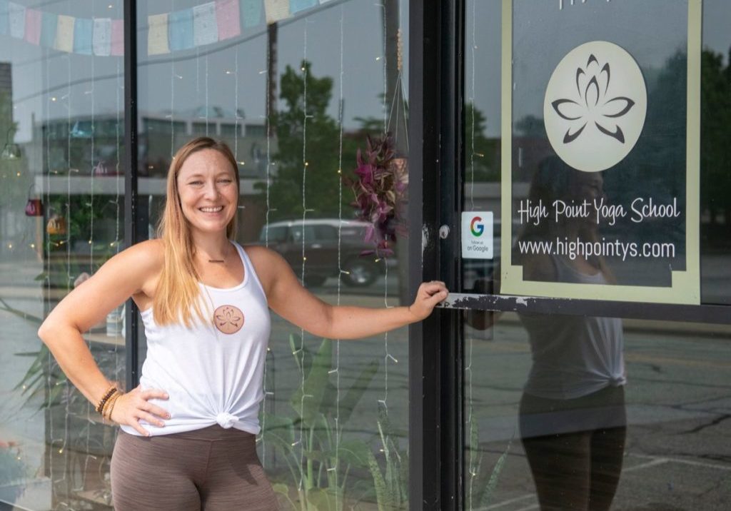 Feature image of High Point Yoga School owner and instructor Jenn Newton stands outside her High Point, NC yoga studio